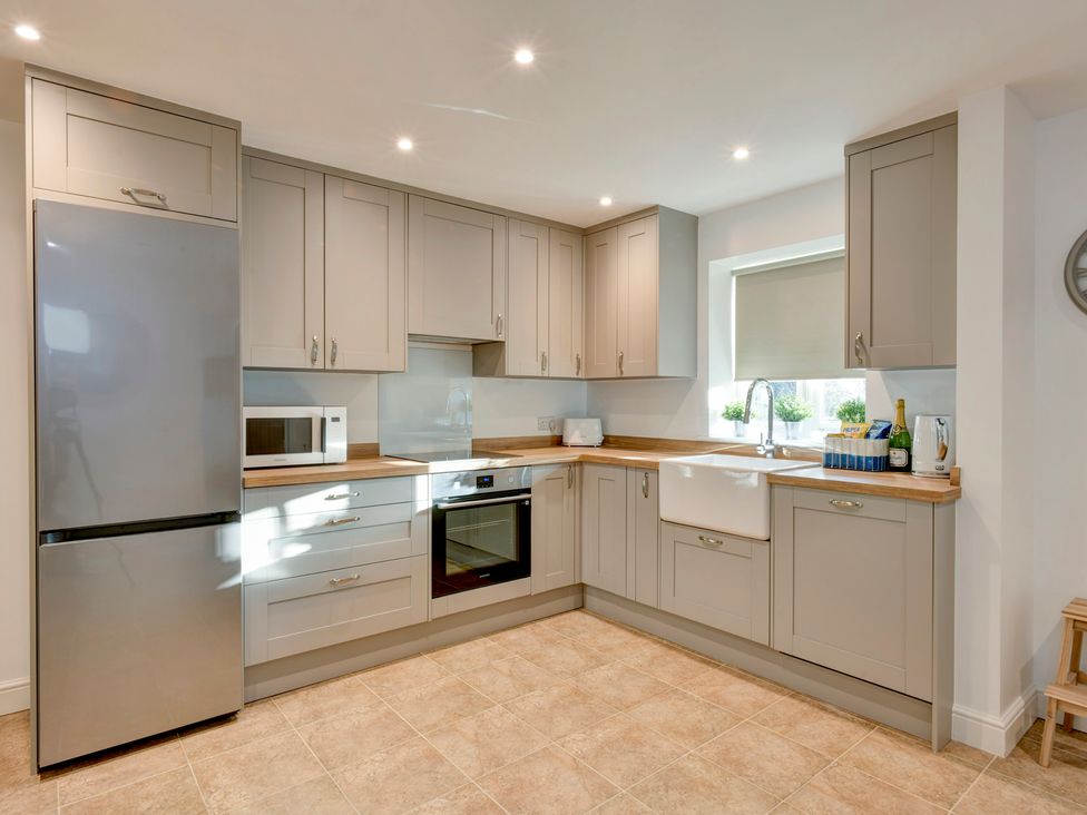 A kitchen with a refrigerator, microwave, oven, and sink at The Old Boat House in Lyme Regis