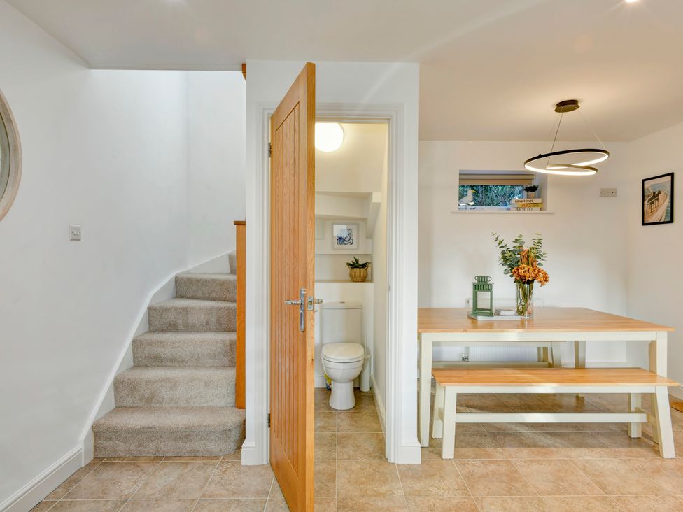 A dining room with a table and toilet visible at The Old Boat House in Lyme Regis