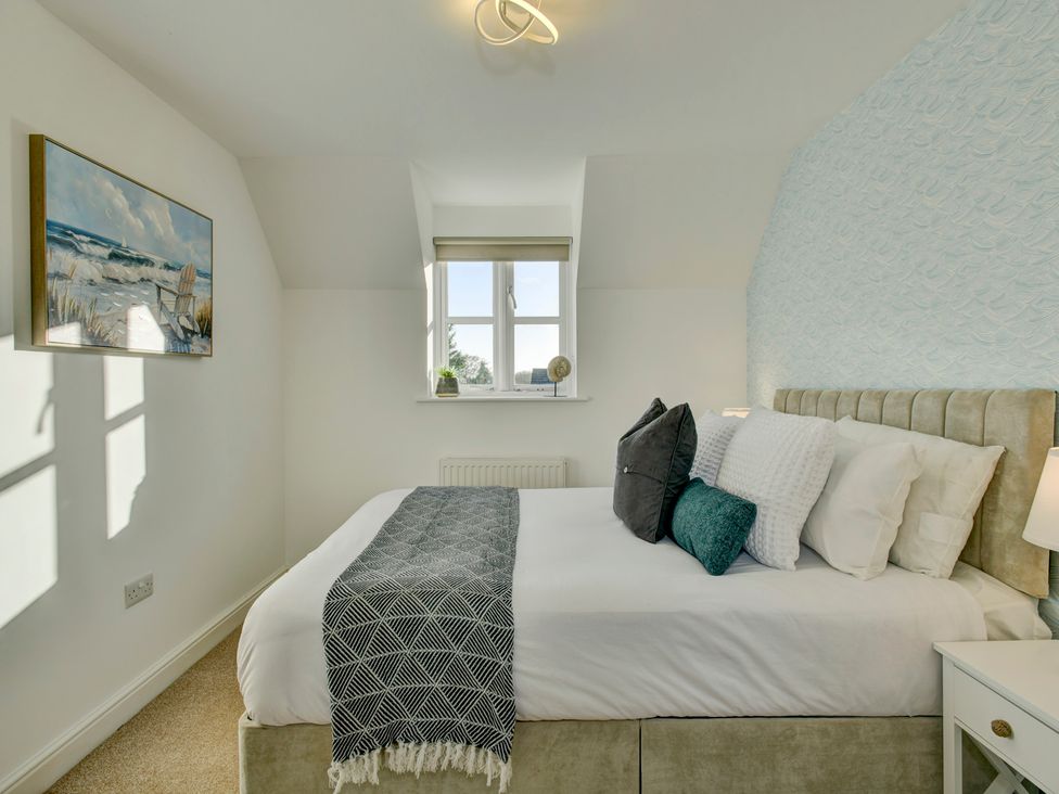 A bedroom with a bed and window at The Old Boat House Lyme Regis