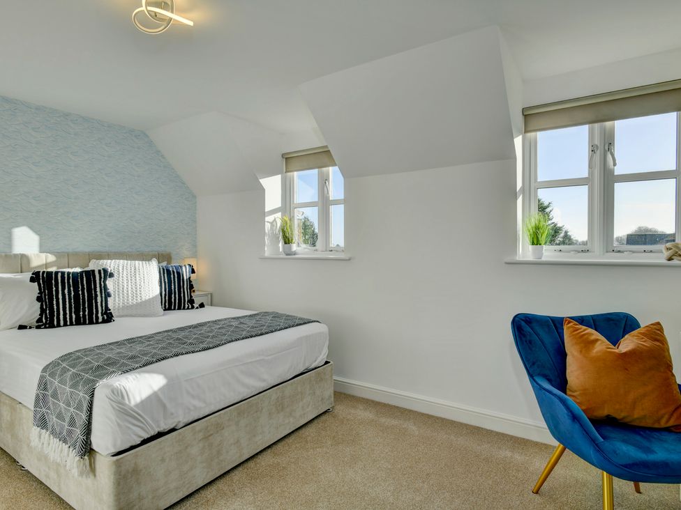 A bedroom with a bed and chair at The Old Boat House in Lyme Regis