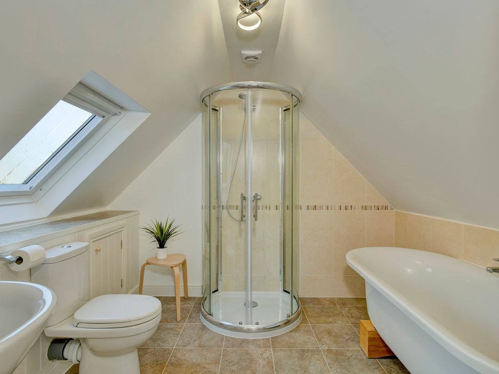 A bathroom with a shower, bathtub, and toilet at The Old Boat House in Lyme Regis