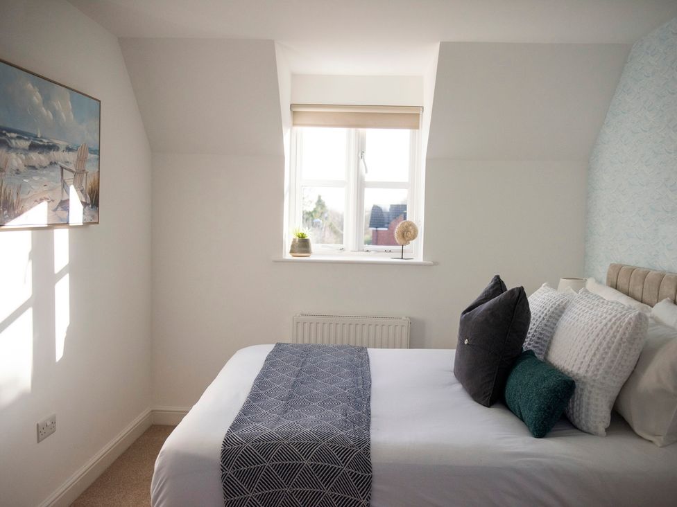A bedroom with a bed and decorative pillows at The Old Boat House in Lyme Regis