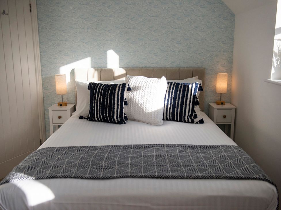 A bedroom with a bed and pillows at The Old Boat House in Lyme Regis