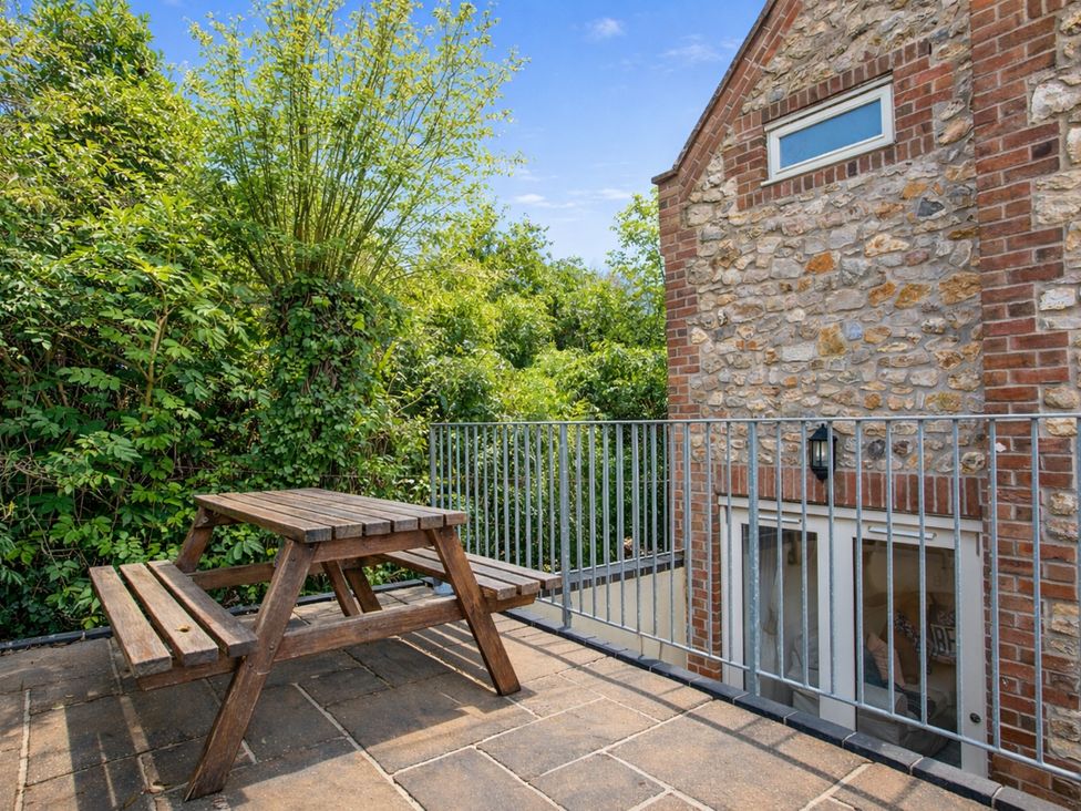 A patio with a table and bench at The Old Boat House in Lyme Regis