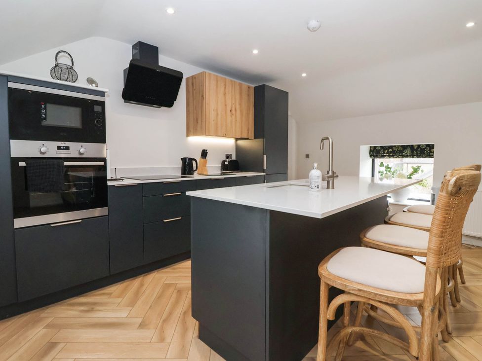A kitchen with a modern design including a kitchen island and appliances at The Old Bakehouse