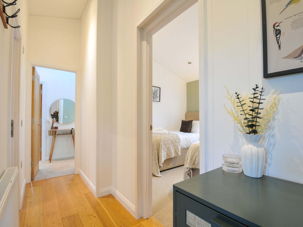 A hallway with a table and doors leading to rooms at 6 Stonerush Valley in Looe