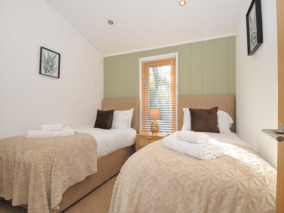 A bedroom with two single beds and a bedside table at 6 Stonerush Valley, Looe