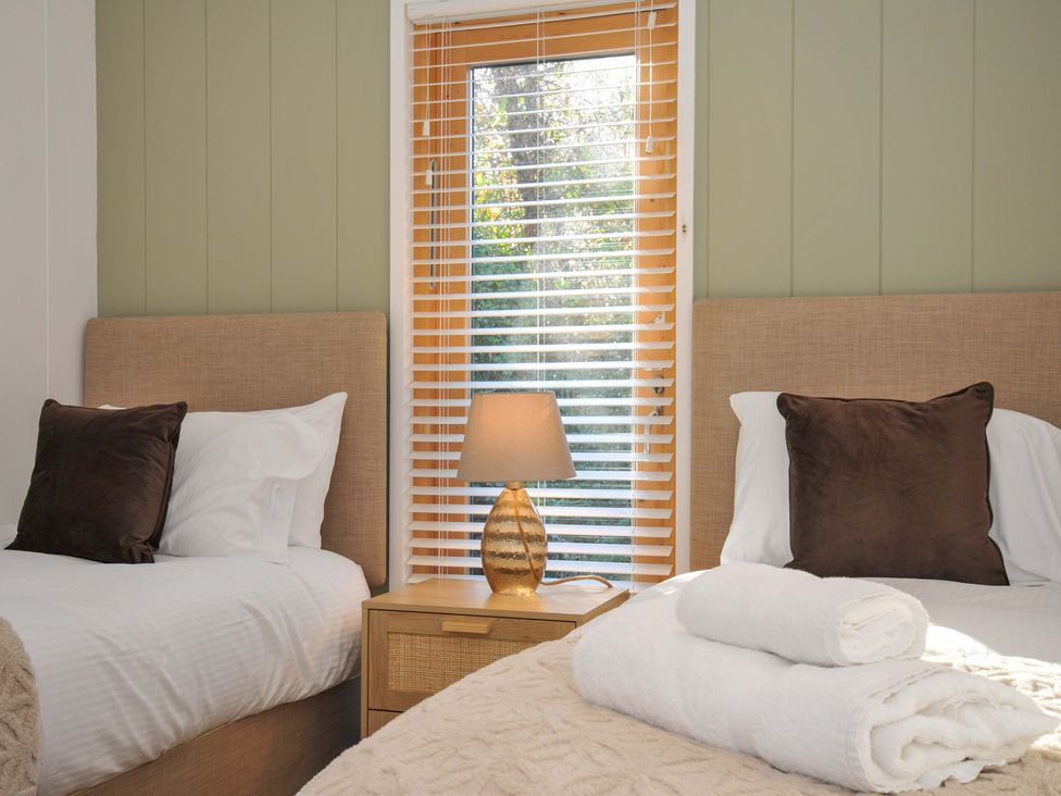 A bedroom with two beds and a window at 6 Stonerush Valley Looe