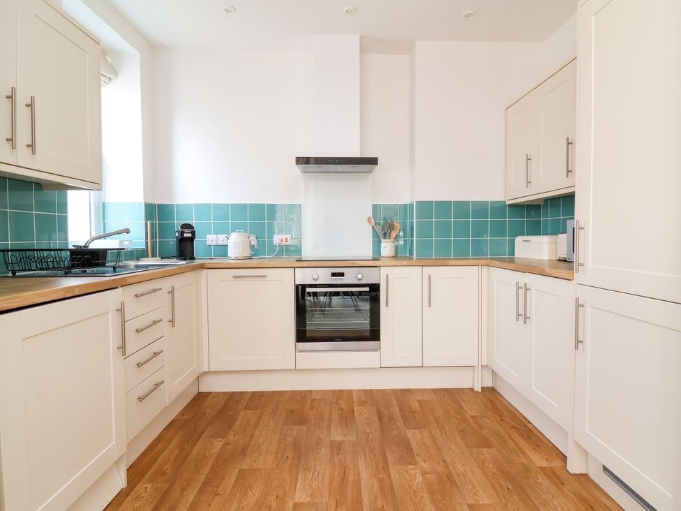 A kitchen with cabinets and appliances at The Old Bank Flat North Tawton