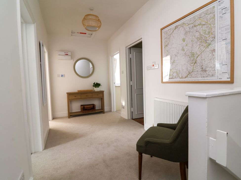A hallway with a console table and mirror at The Old Bank Flat in North Tawton