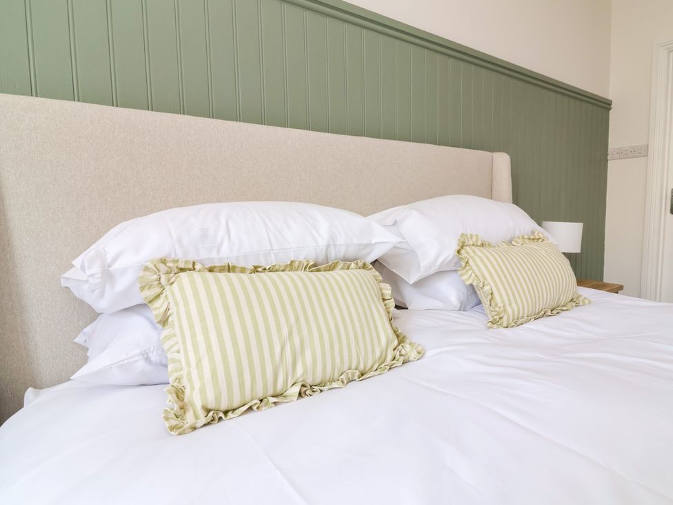A bedroom with a bed and decorative pillows at The Old Bank Flat North Tawton