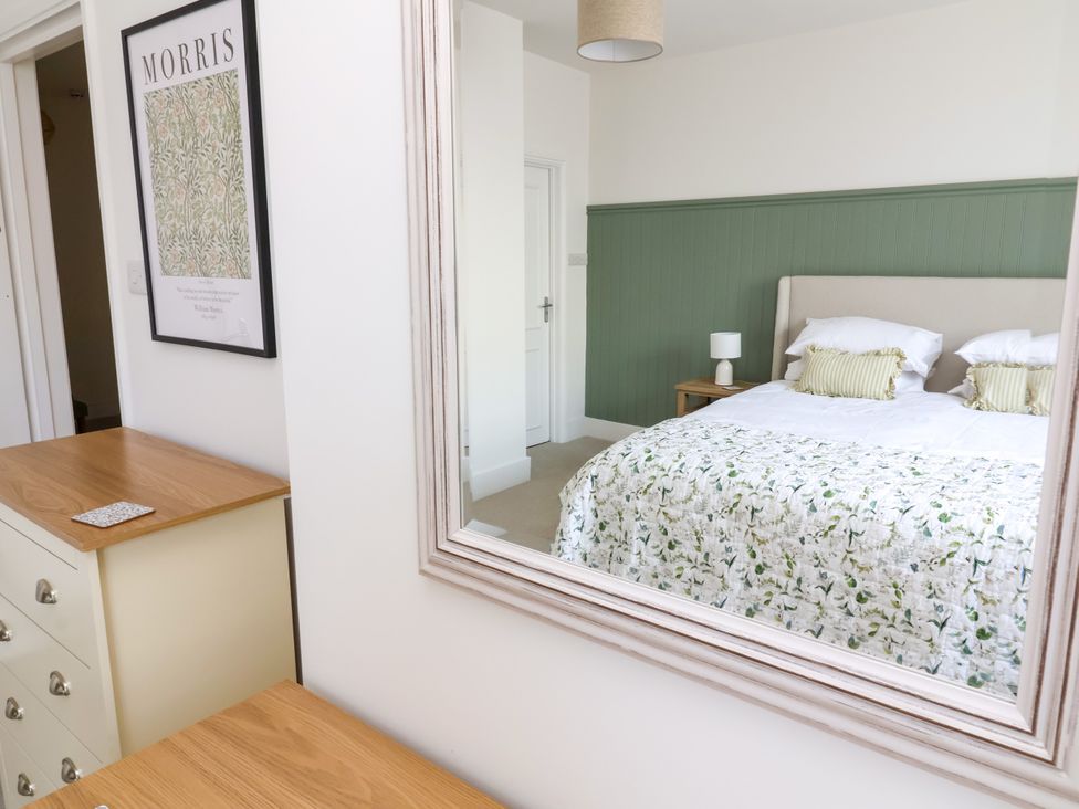 A bedroom with a bed and nightstand at The Old Bank Flat North Tawton