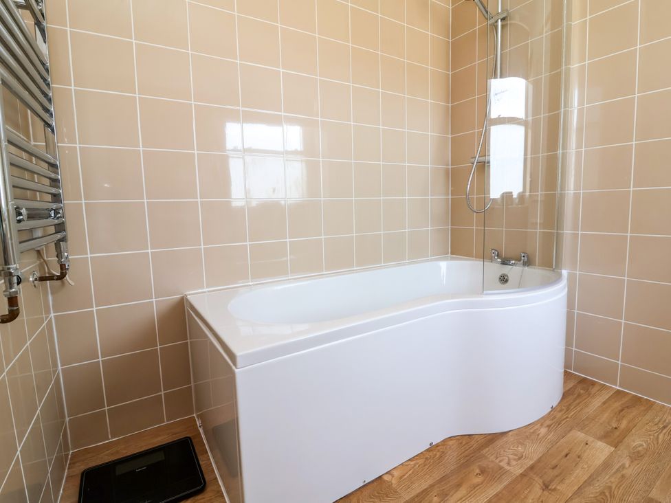 A bathroom with a bathtub and shower at The Old Bank Flat in North Tawton