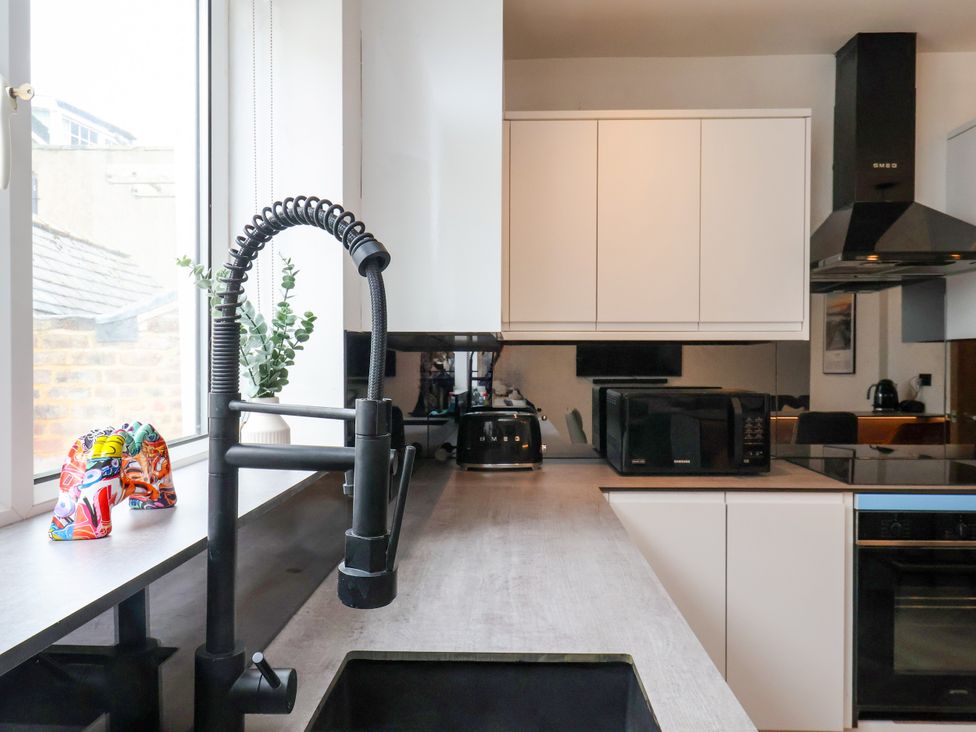 A kitchen with a sink, tap, and appliances at OG's House in Whitby