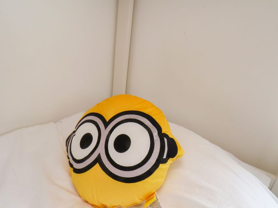 A Minion character pillow on a bed at OG's House in Whitby