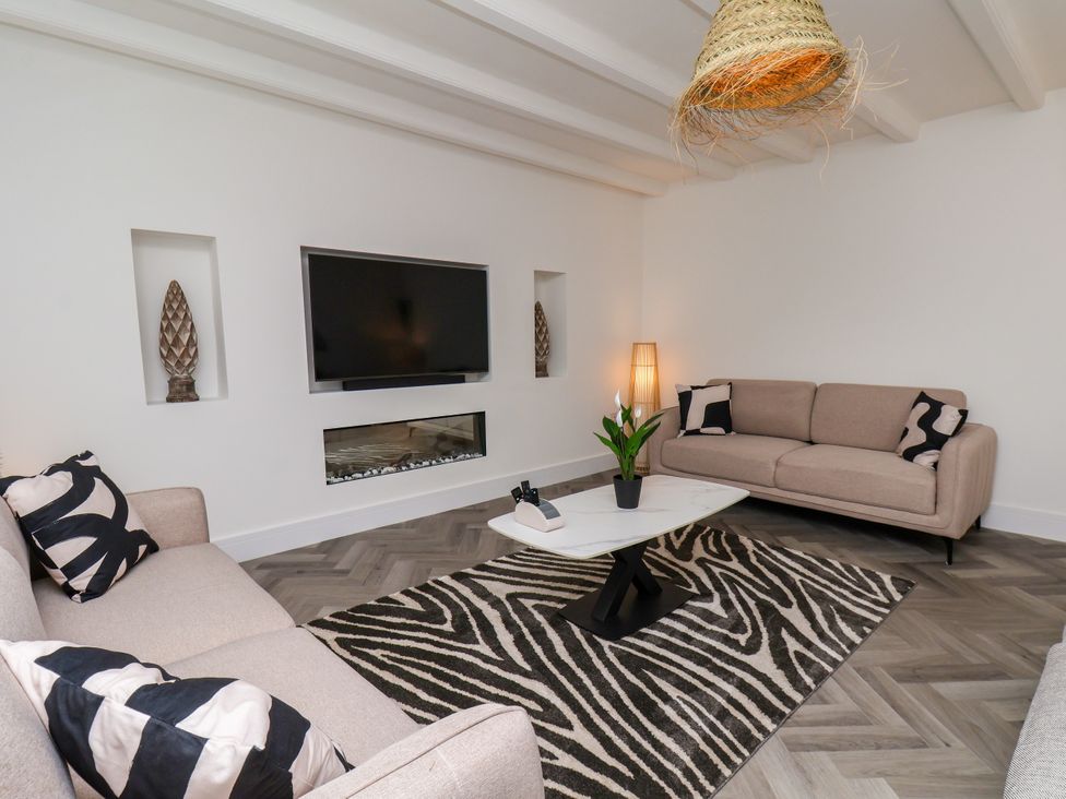 A living room with a television, sofa, and coffee table at Og's House in Whitby