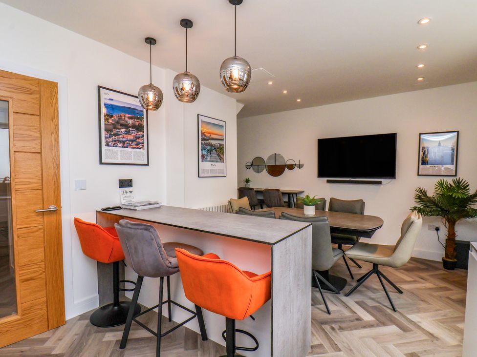 A dining room with a table and bar stools at Og's House Whitby