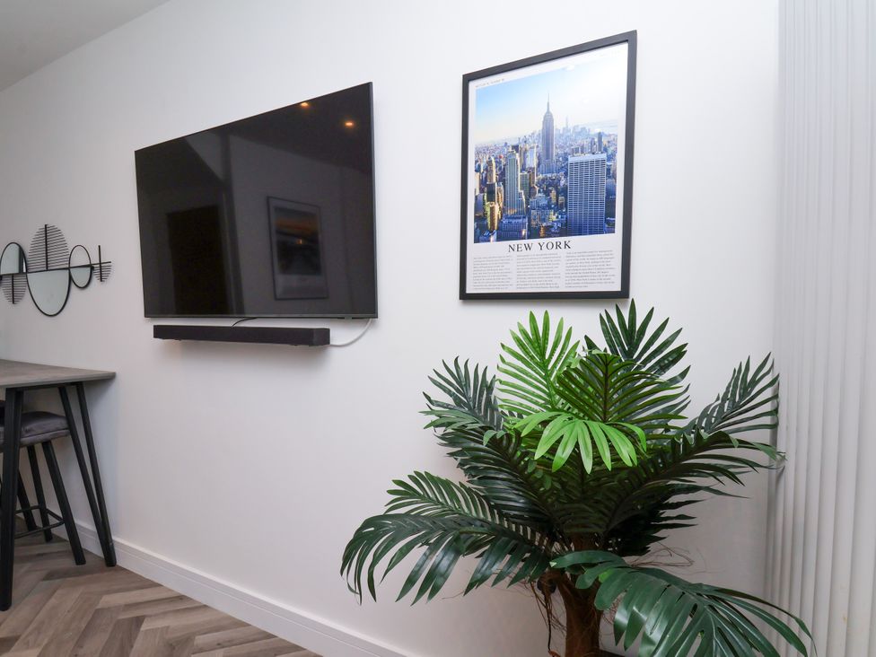 A living room with a television and wall art at Og's House in Whitby