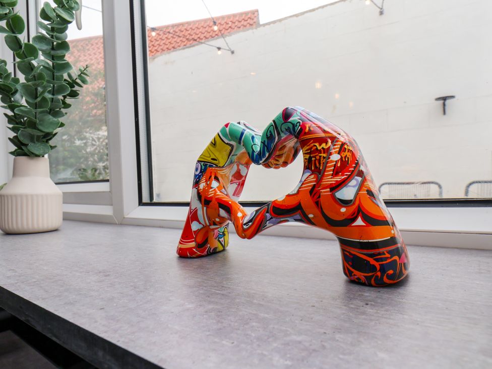 A sculpture and plant on a table near a window at Og's House in Whitby