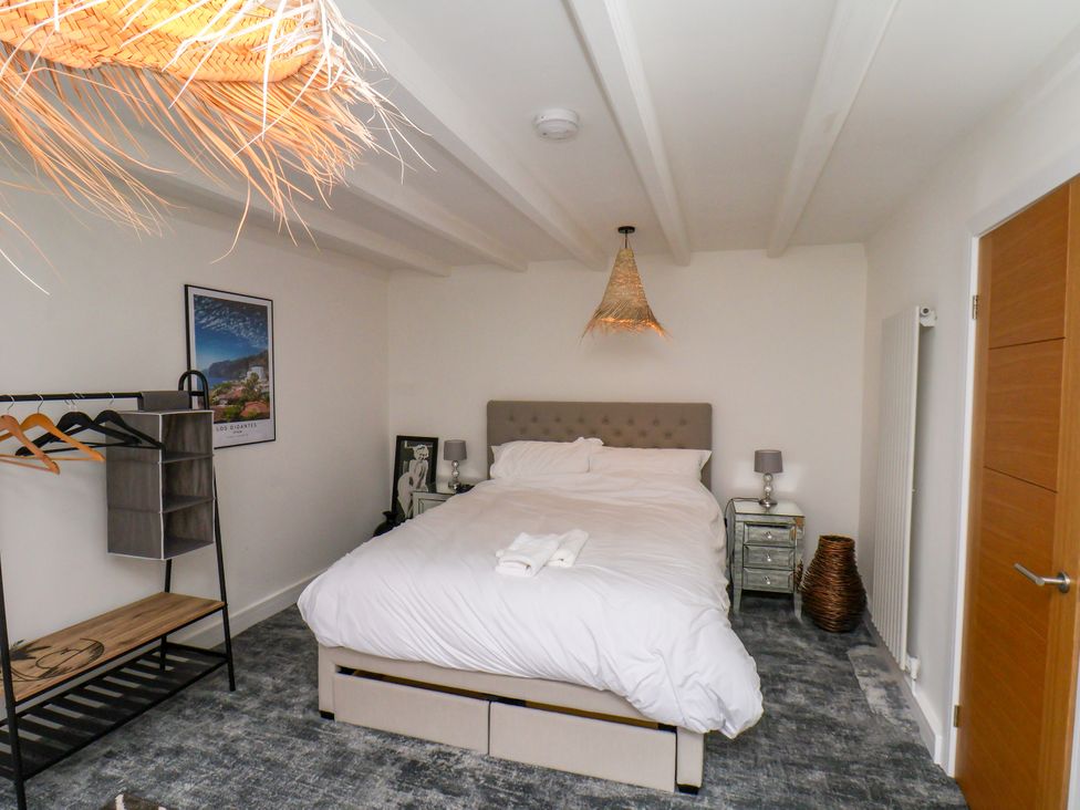 A bedroom with a bed and a clothes rack at Og's House in Whitby