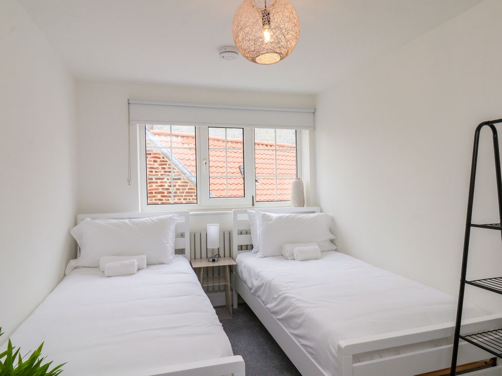 A bedroom with two beds and a window at Og's House in Whitby