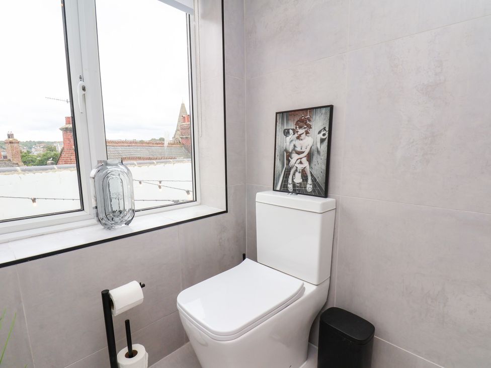 A bathroom with a toilet and window at Og's House in Whitby