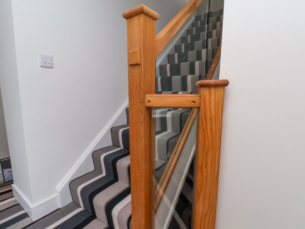 A staircase with a wooden railing at Og's House in Whitby