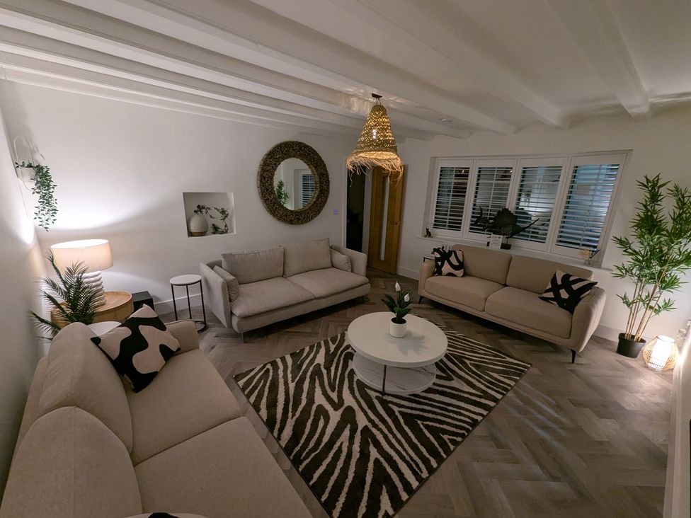 A living room with two sofas, a coffee table, and a lamp at Og's House in Whitby