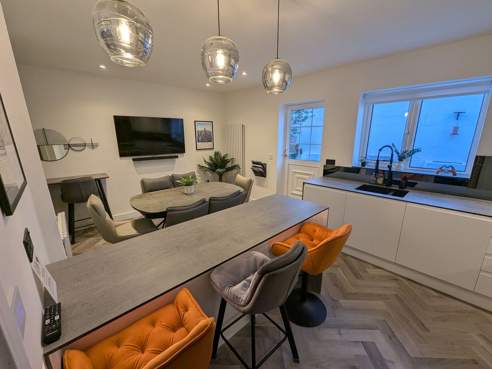 A kitchen with a dining table and television at Og's House in Whitby