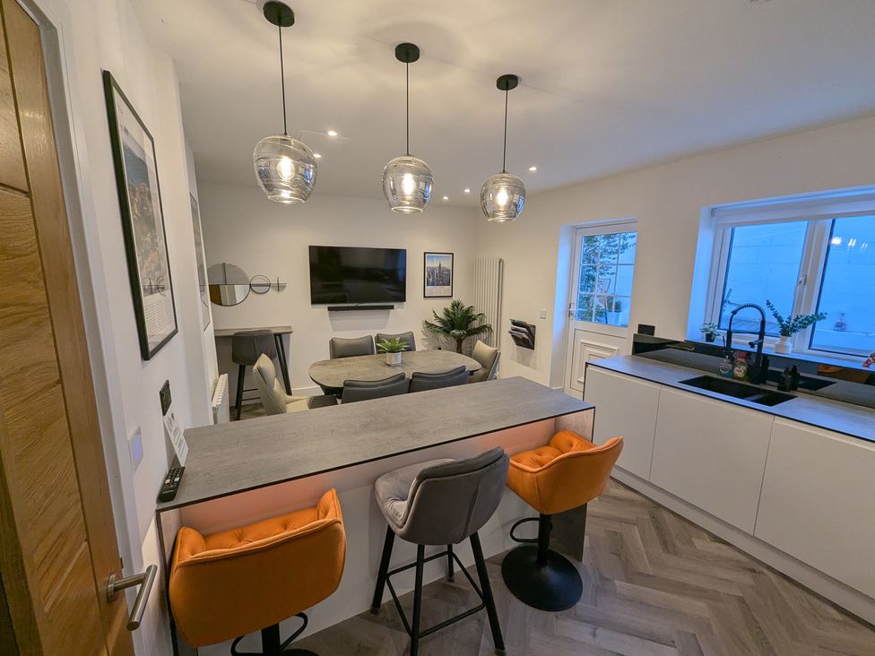 A kitchen with a bar counter and stools at Og's House in Whitby