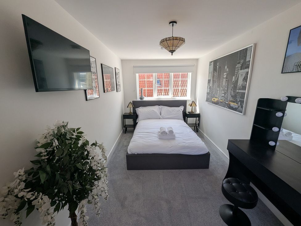 A bedroom with a bed, television, and vanity at Og's House in Whitby