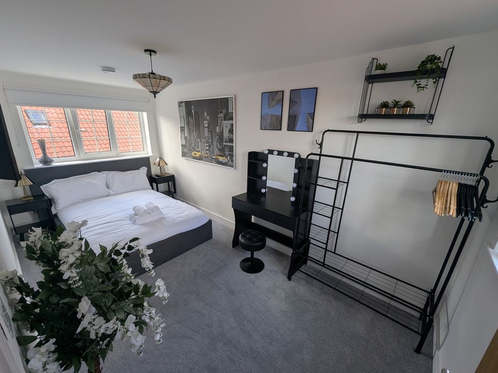 A bedroom with a bed and a mirror at Og's House in Whitby