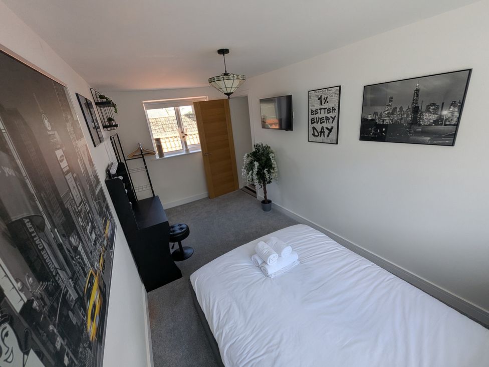A bedroom with a bed and wall art at Og's House in Whitby