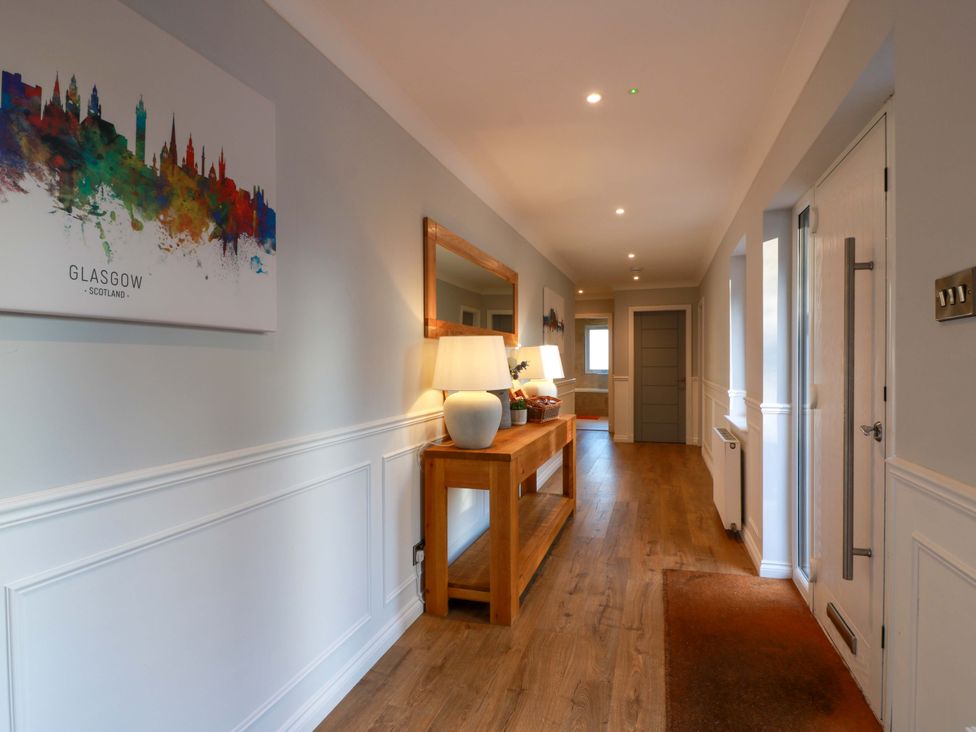 A hallway with a mirror and console table at Cramar Cottage