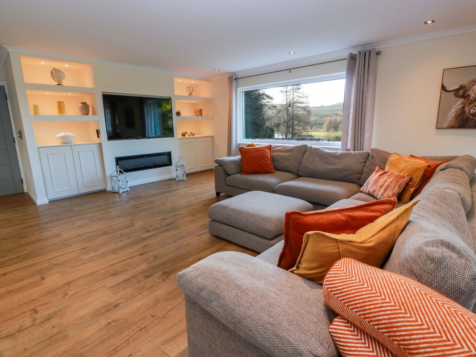 A living room with a sofa and television at Cramar Cottage