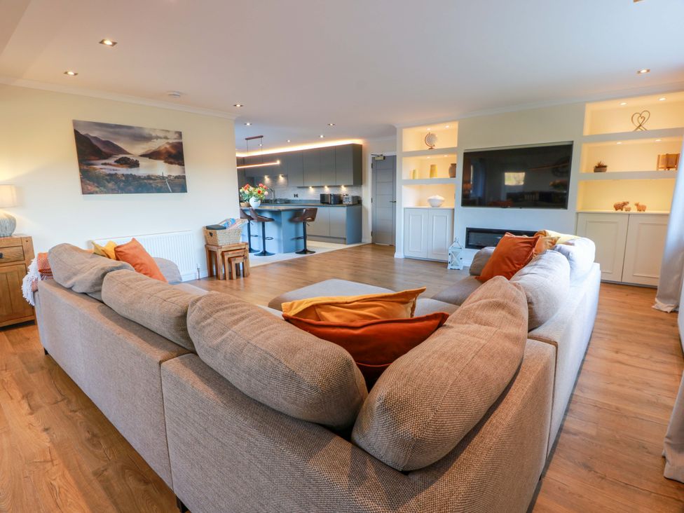 A living room with a sofa and television at Cramar Cottage