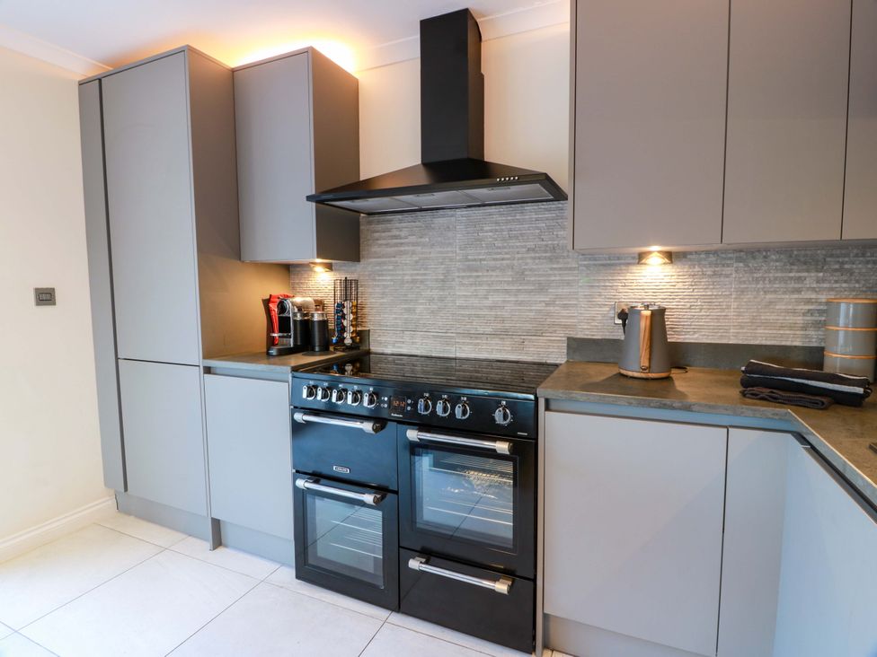 A kitchen with cabinets and an oven at Cramar Cottage