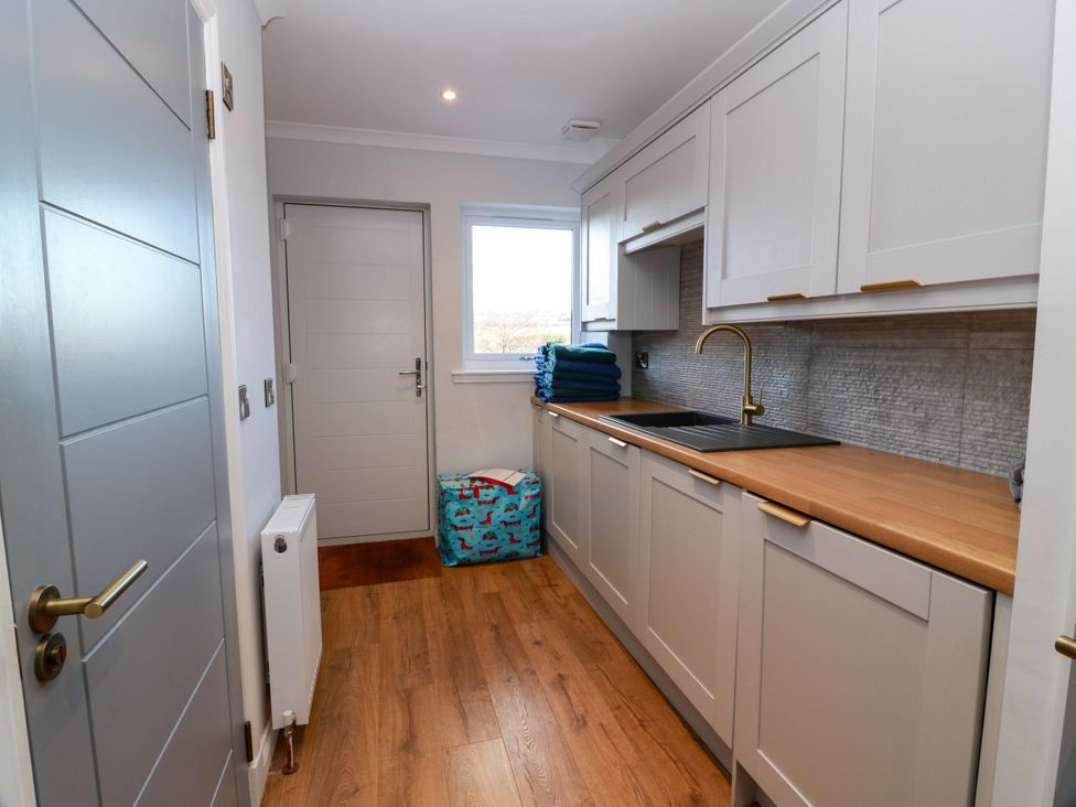 A kitchen with cabinets and a sink at Cramar Cottage