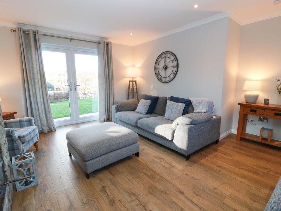 A living room with a sofa and ottoman at Cramar Cottage