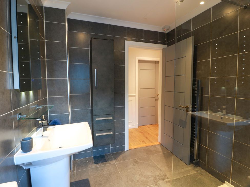 A bathroom with a sink and a cabinet at Cramar Cottage