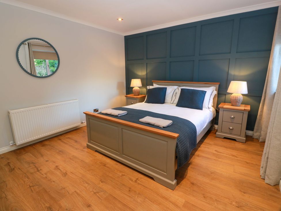 A bedroom with a bed and nightstands at Cramar Cottage in 