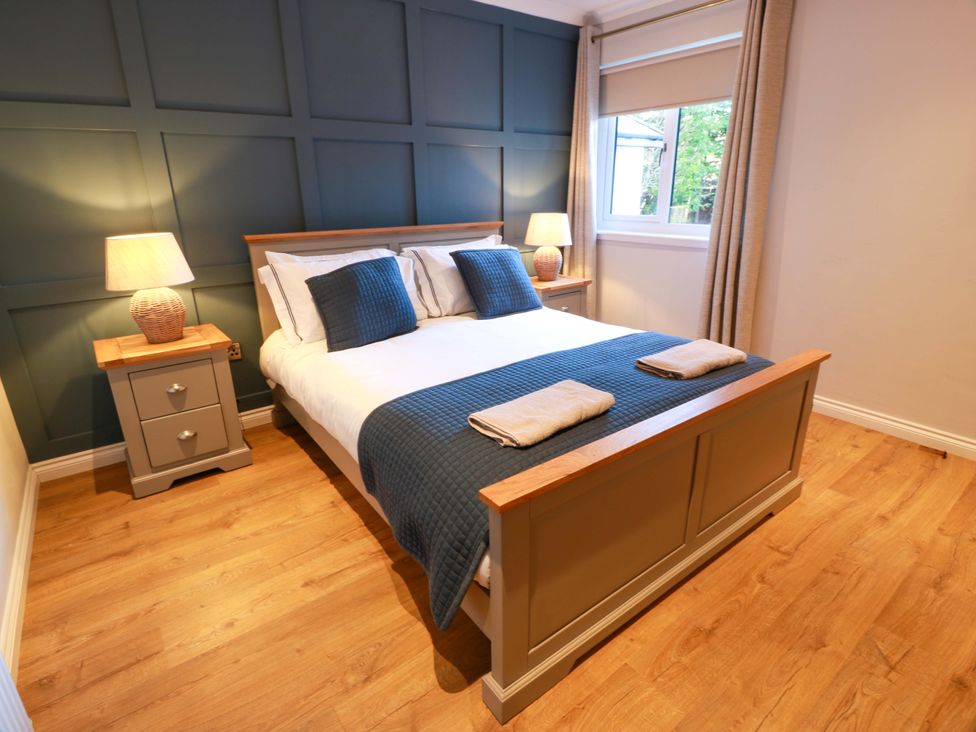 A bedroom with a bed and bedside tables at Cramar Cottage