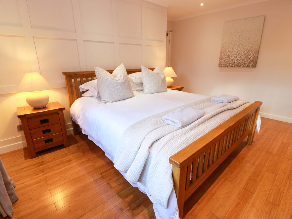 A bedroom with a bed and bedside table at Cramar Cottage