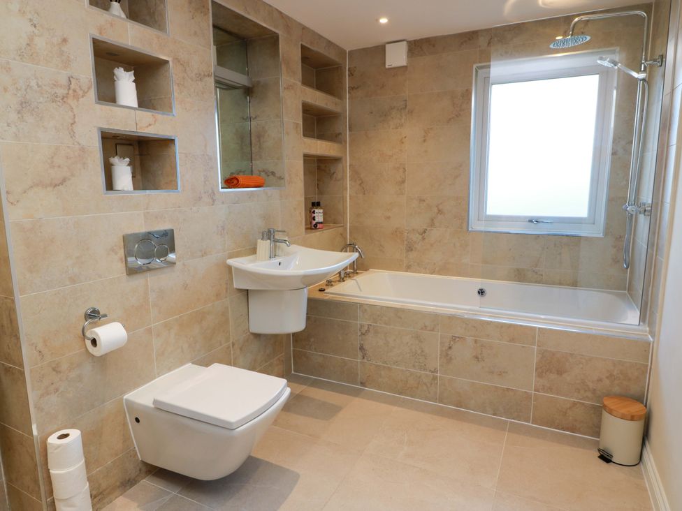 A bathroom with a bathtub and sink at Cramar Cottage