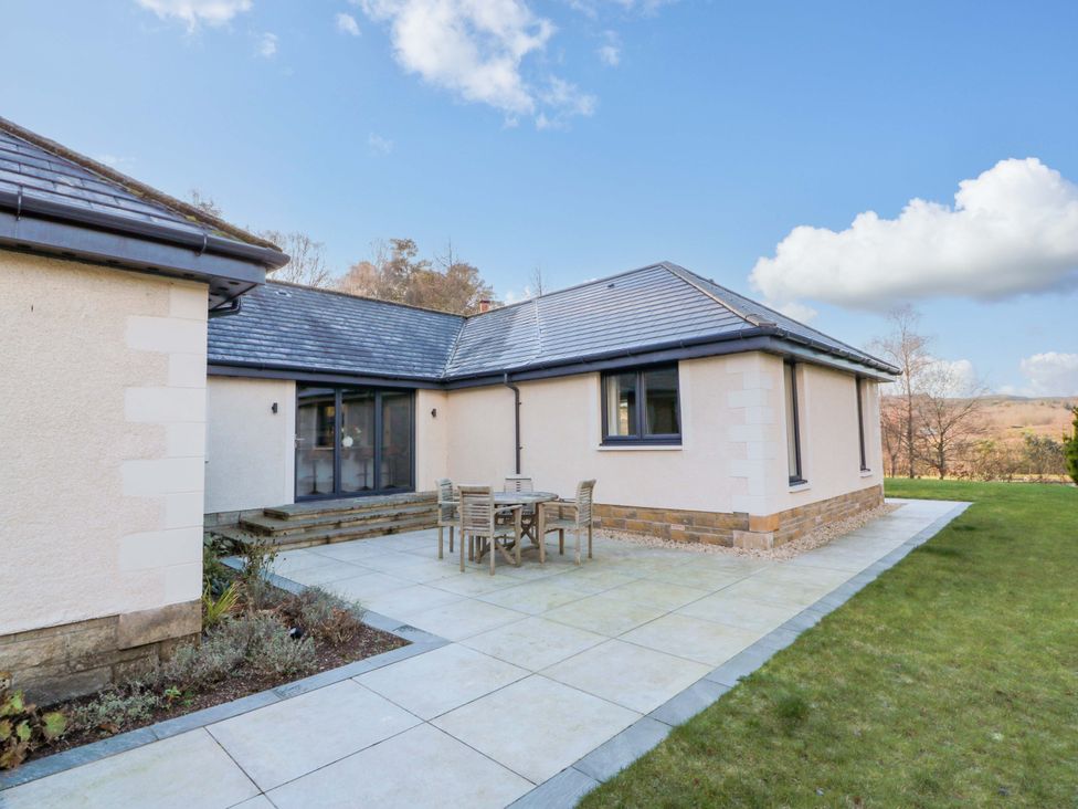 A house with a patio and outdoor seating at Cramar Cottage in 