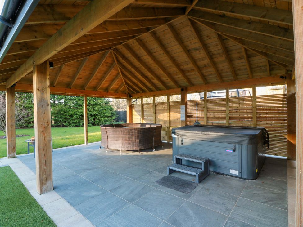 An outdoor space with a hot tub and seating area at Cramar Cottage