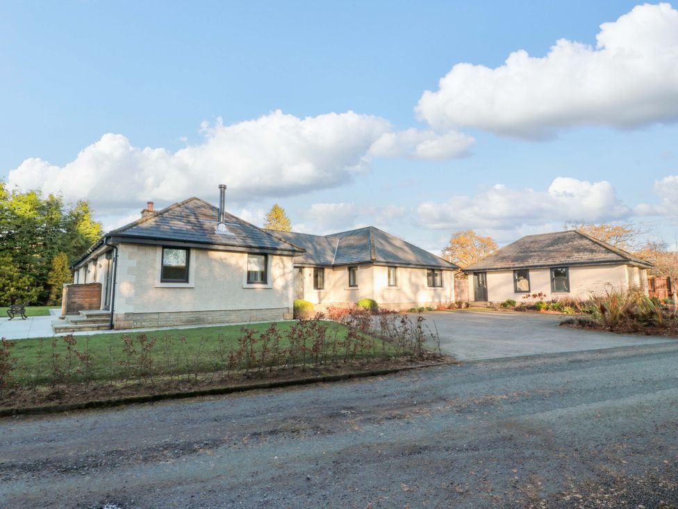 A house with a driveway and gardens at Cramar Cottage