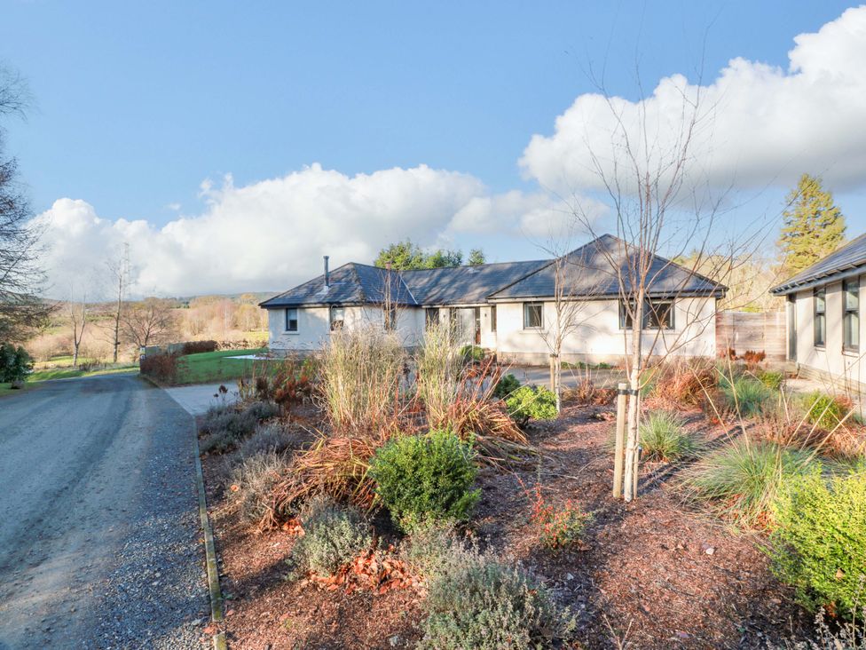 An exterior view of a house with a driveway and garden at Cramar Cottage 