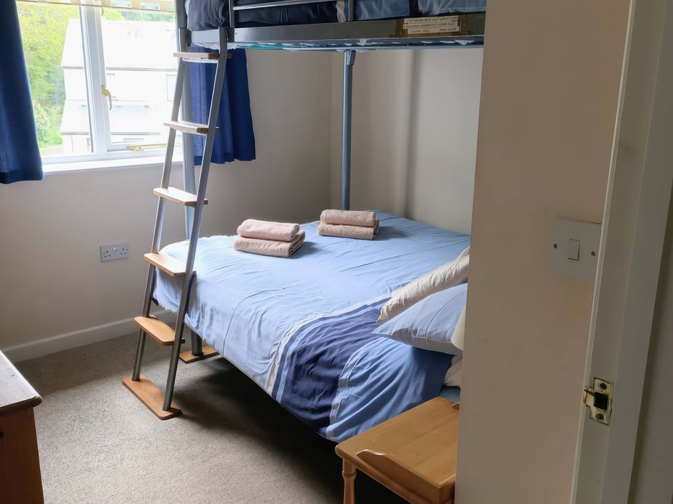 A bedroom with a bunk bed and towels at 29 Pendra Loweth in Falmouth