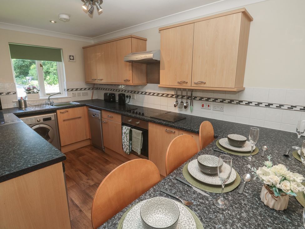 A kitchen with wooden cabinets and a counter at Stargazy in Falmouth